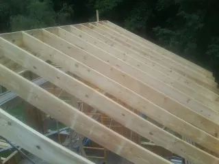 New roof rafters set over an addition before sheathing in Bethel